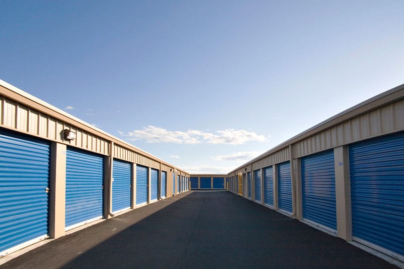 typical storage facility, real estate investment - blue storage doors outside